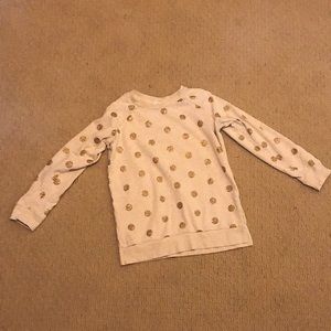 A tan with gold polka dotted sweater